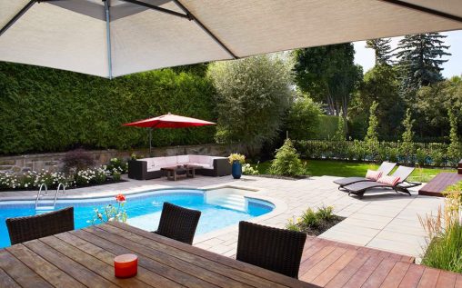 Aménagement de cour avec piscine creusée, table à manger et espace détente