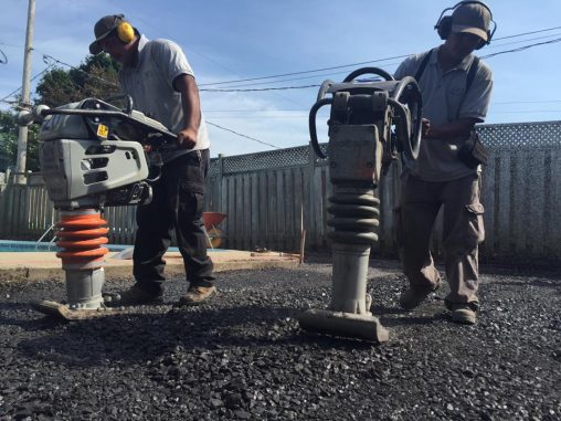 Deux ouvriers qui égalisent un terrain