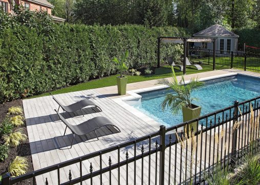 Cour arrière clôturée avec piscine creusée et chaises longues