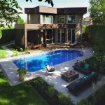 Aménagement paysager arrière, avec piscine, foyer et divans extérieurs