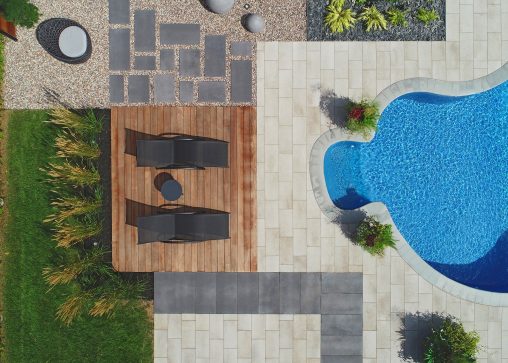 Chaises longues à côté d'une piscine creusée vues à vol d'oiseau