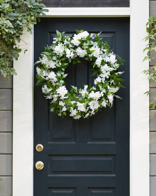 Couronne ornée de fleurs blanches sur une porte d'entrée
