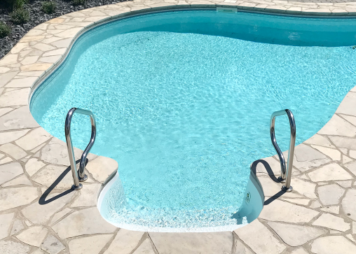 Piscine creusée entourée de dalles de pierre naturelle calcaire beige