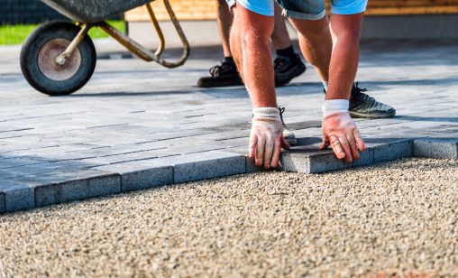 Ouvrier qui installe des petites dalles de pavé à la main