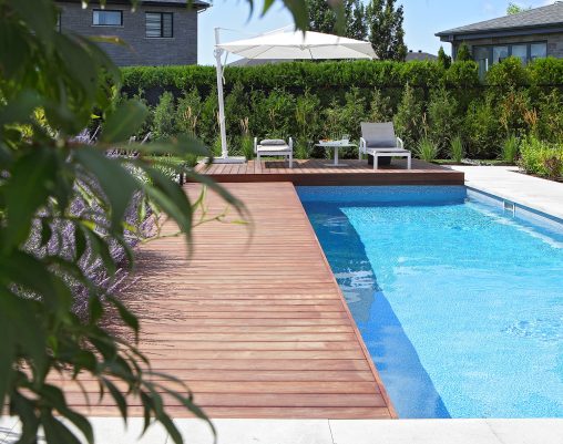 Piscine creusée résidentielle avec contours en bois et dalles de béton