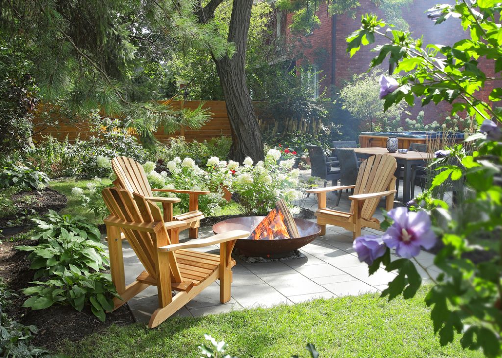 Espace foyer avec chaises Adirondack entouré de plantes