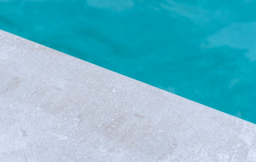 Texture du béton en contraste avec l'eau d'une piscine