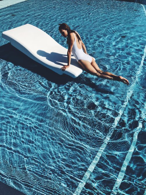 Femme sur un sundeck dans une piscine luxueuse