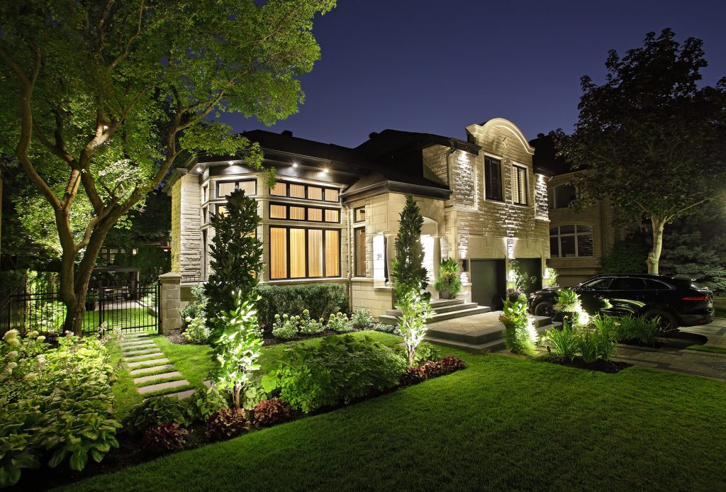 Example of our hedge trimming service with a beautiful home surrounded by neatly trimmed bushes and a pristine lawn.